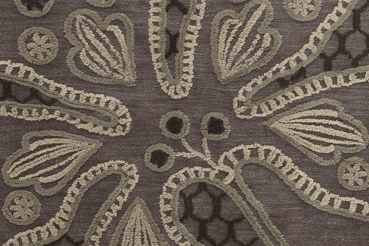 Detail eines Teppichs mit floralem und ornamentalem Muster.