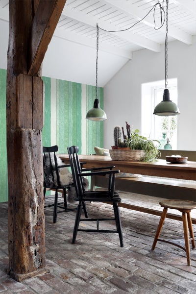 Esszimmer mit Holztisch, Stühlen, Deckenleuchten und dekorativer Wandgestaltung