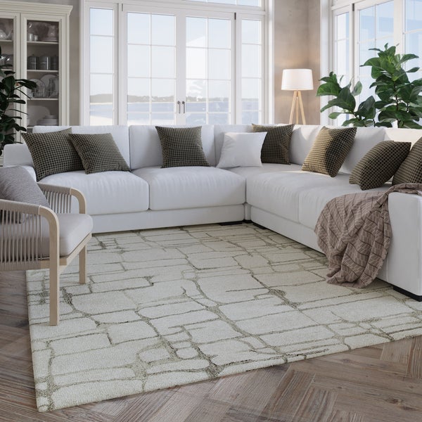 Helles, modernes Wohnzimmer mit großem weißem Ecksofa, gemustertem Teppich auf Fischgrätparkett und großen Fenstern.