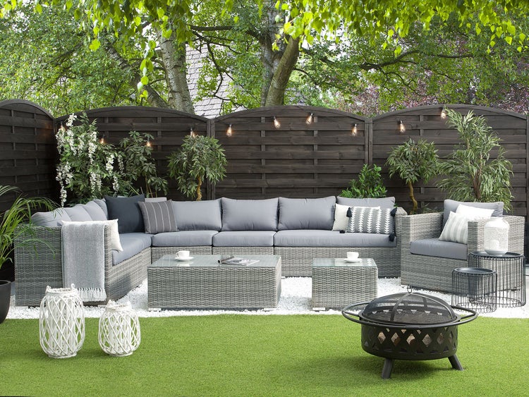 Gartenlounge-Set mit Rattansofa, Couchtisch, Sesseln und Feuerstelle auf Kunstrasen