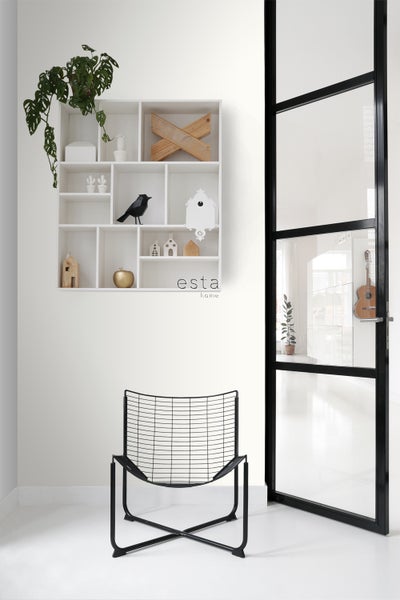 Helle Raumansicht mit einem offenen Regal gefüllt mit Dekoration, einem Stuhl und einer Glastür