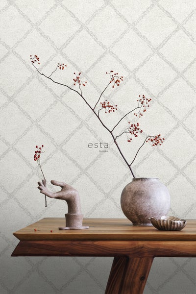 Dekoratives Stillleben mit Vase, Skulptur und gemusterter Tapete