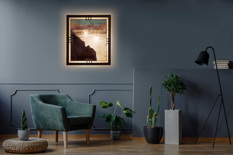 Wohnzimmer mit einem grünen Sessel, einer Stehlampe und einem beleuchteten Wandbild