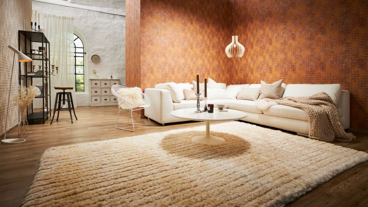 Wohnzimmer mit Sofa, Teppich und dekorativer Wandgestaltung