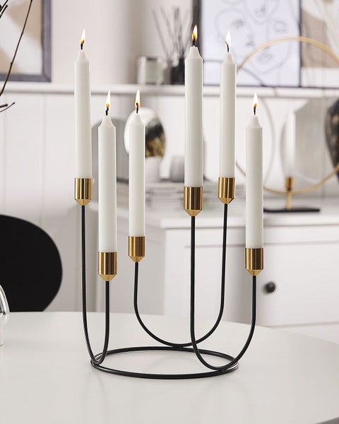 Kerzenständer mit sechs weißen Kerzen auf einem Tisch