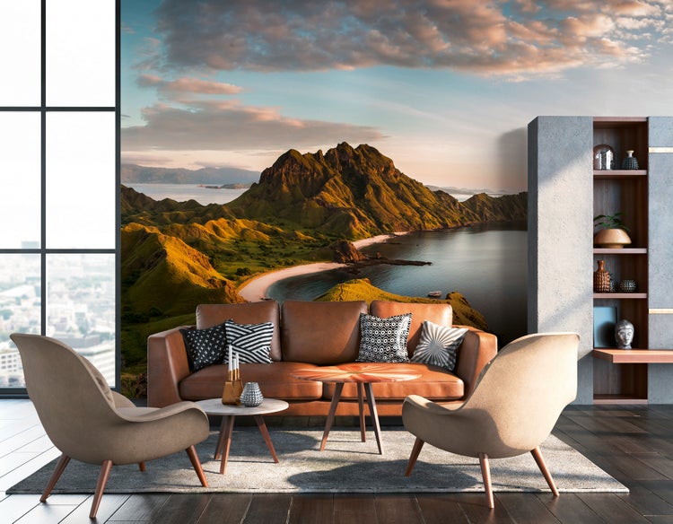 Fototapete mit Küstenlandschaft und Bergen in einem modern eingerichteten Wohnzimmer mit Ledersofa, Sesseln und dunklem Holzboden.