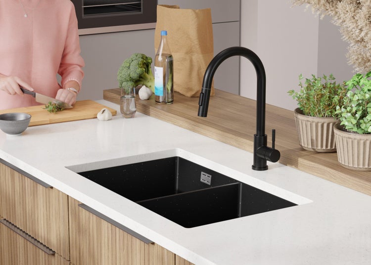 Küchenszene mit Doppelspüle, Armatur und Küchenutensilien auf einer Arbeitsplatte