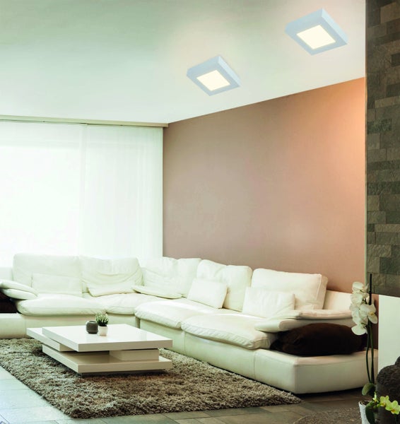 Helles Wohnzimmer mit Ecksofa, Couchtisch, Teppich und Deckenleuchten