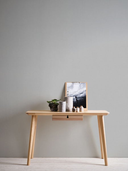 Dekoratives Arrangement auf einem Holztisch mit Schublade