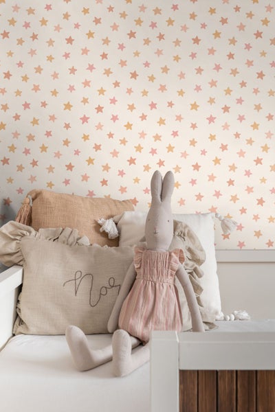 Kinderzimmer mit Sternen Tapete und Stofftier auf dem Bett