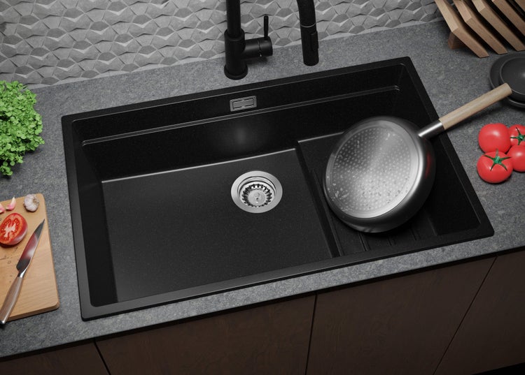 Schwarzes Spülbecken mit Abtropffläche, Wasserhahn und Küchenutensilien