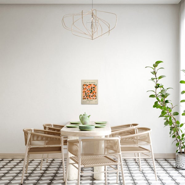 Esszimmer mit Esstisch, Stühlen, Zimmerpflanze, Lampe und einem Bild mit Früchtemotiv.