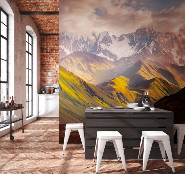 Heller Raum mit Ziegelwänden, Holzboden, Küchentheke, Barwagen und einer Fototapete mit Bergmotiv.