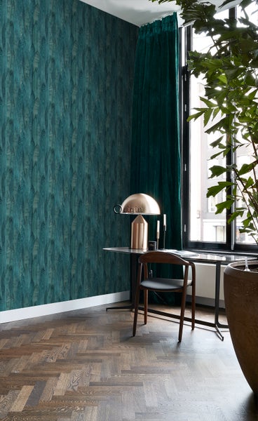 Wohnzimmer mit gemusterter Tapete, Schreibtisch, Stuhl und Pflanze