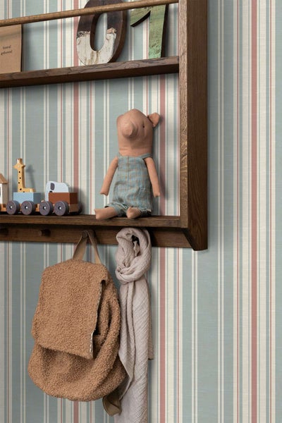 Wand mit Vliestapete im vertikalen Streifendesign, dekoriert mit einem hölzernen Wandregal, Kinderspielzeug und einem Rucksack.