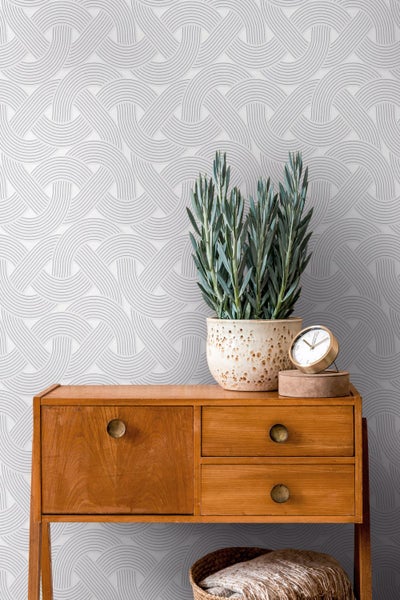 Wohnzimmer mit geometrischer Tapete, Sessel und Stehlampe