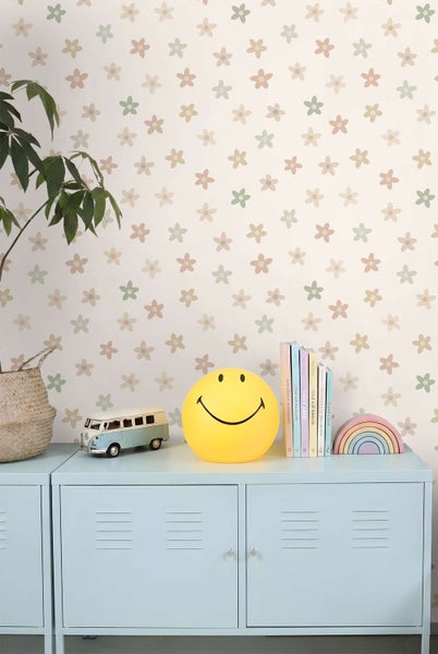 Vliestapete mit Blumenmuster für das Kinderzimmer, tapeziert in einem hellen Raum mit Kommode und dekorativen Kinderspielzeugen.