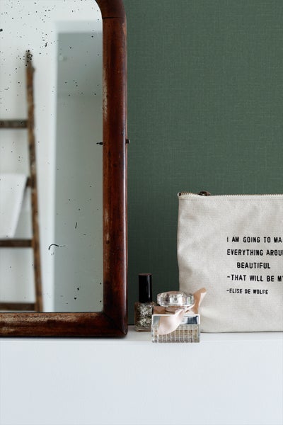 Dekorative Szene mit Spiegel, Nagellack, Parfüm und Kosmetiktasche.