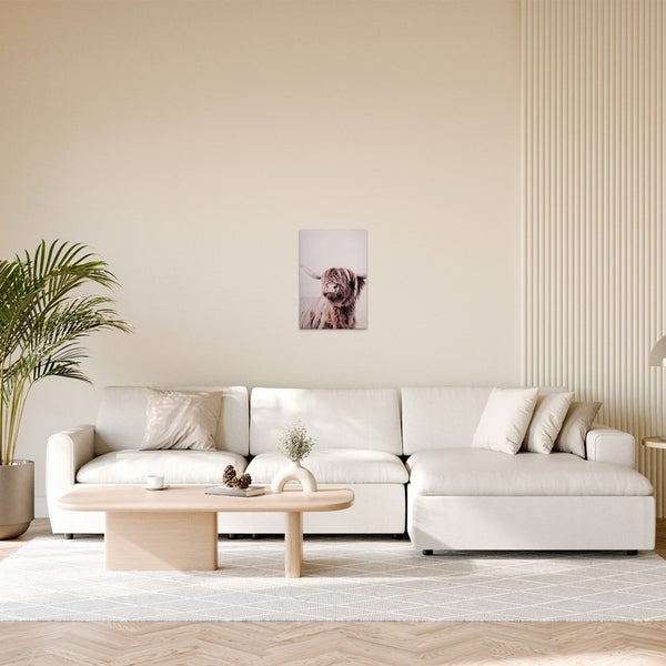 Wohnzimmer mit Sofa, Couchtisch und einem Bild eines Hochlandrindes