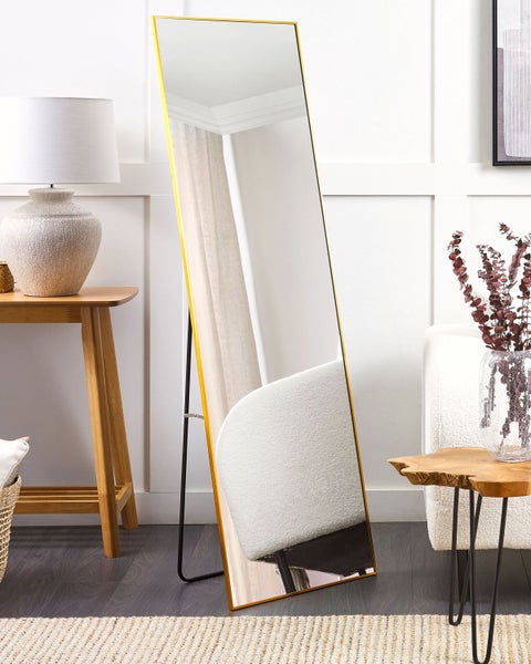 Rechteckiger Spiegel mit goldfarbenem Rahmen und Standfuß in einem Wohnzimmer