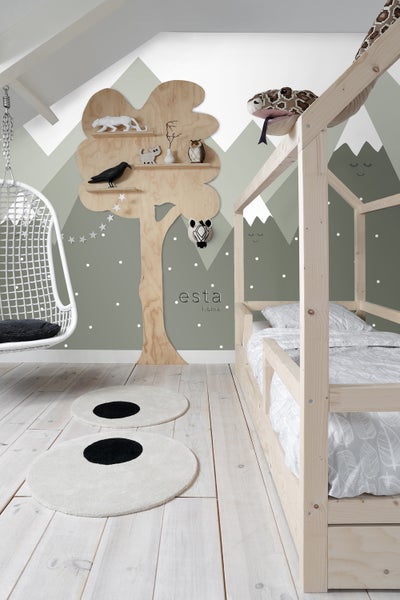 Dekoriertes Kinderzimmer mit Himmelbett, Schaukelstuhl und Baumregal