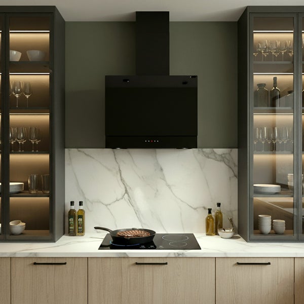 Moderne Küche mit schwarzer Wand Dunstabzugshaube über Induktionskochfeld, Marmor Rückwand und beleuchteten Glasschränken.