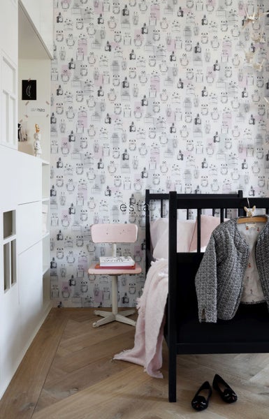 Ein Kinderzimmer mit einem schwarzen Bett, einem rosa Stuhl und einer Tapete mit Parfümflaschenmuster.