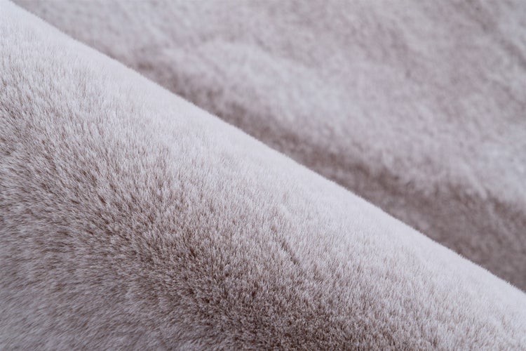 Detailaufnahme der Textur eines weichen Kunstfell-Teppichs mit dichtem Flor.
