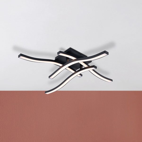 Schwarze LED Deckenleuchte mit geschwungenen Lichtelementen an der Decke montiert.