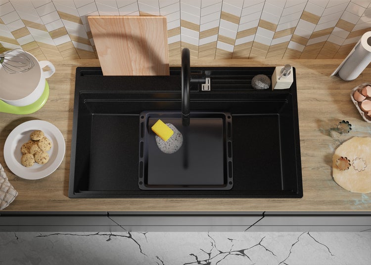 Schwarzes Spülbecken mit Küchenutensilien und Lebensmitteln auf einer Arbeitsplatte
