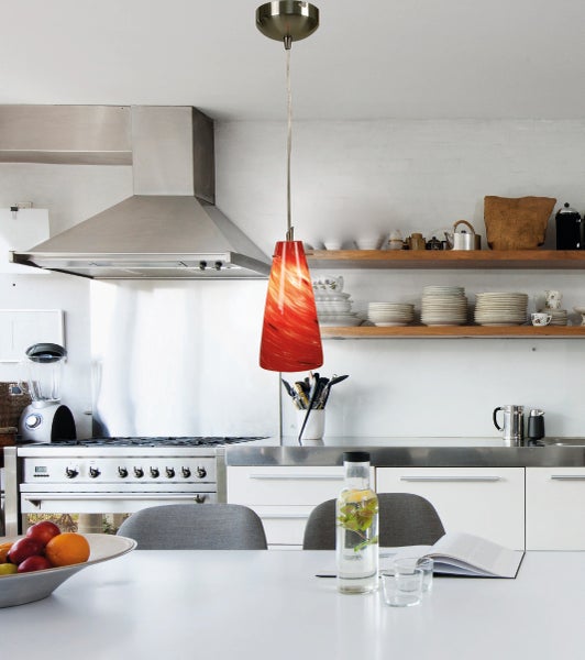 Moderne Küche mit Dunstabzugshaube und auffälliger Hängeleuchte über dem Esstisch.
