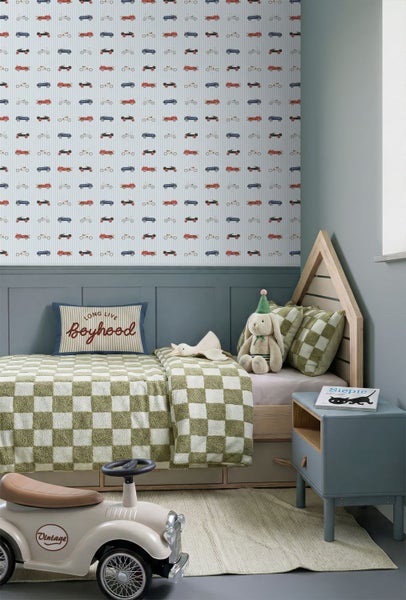 Kinderzimmer mit Vliestapete im Oldtimer-Design, Hausbett aus Holz, karierter Bettwäsche und einem Retro-Rutschauto.
