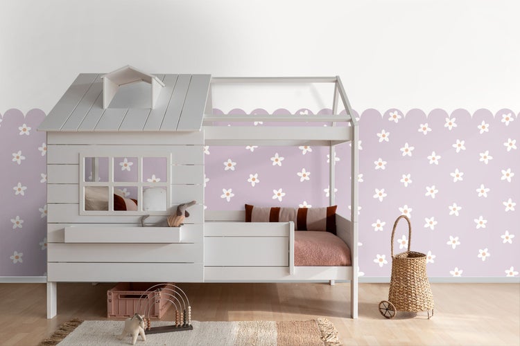 Kinderzimmer mit weißem Spielbett in Hausform, dekoriert mit Textilien und Spielzeug.