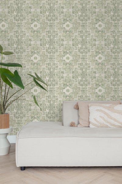 Wohnzimmer mit orientalisch gemusterter Tapete, Couch und Zimmerpflanze