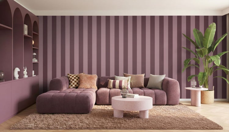 Modernes Wohnzimmer mit lila gestreifter Tapete, modularem lila Sofa, rundem Terrazzo-Couchtisch und einer großen Zimmerpflanze.