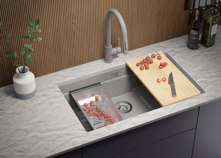 Küchenspüle mit Armatur, Schneidebrett und Abtropfsieb im modernen Küchendesign.
