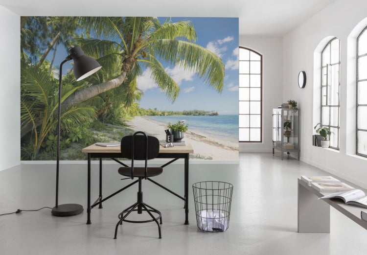 Büro mit Fototapete einer tropischen Strandlandschaft, Schreibtisch, Bürostuhl und Stehlampe