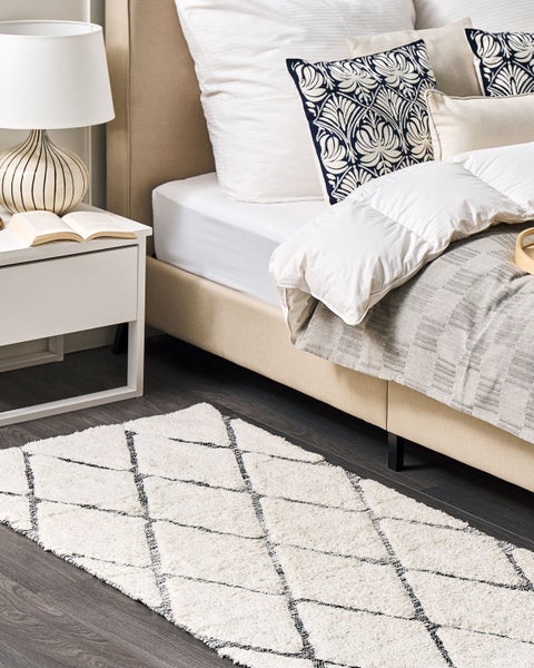 Hochflor-Teppich mit Rautenmuster in Beige und Schwarz sowie Detailansicht der weichen Textur.