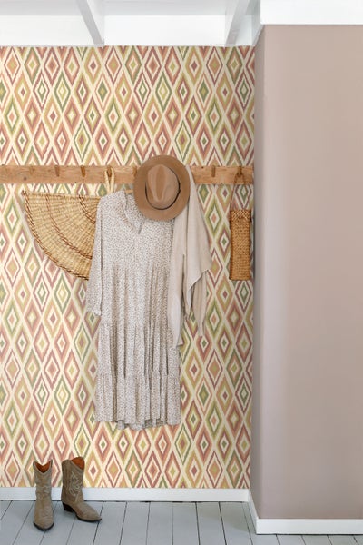 Gemusterte Tapete mit geometrischen Rautenmuster, Holzgarderobe, Kleid, Hut und Stiefel im Raum