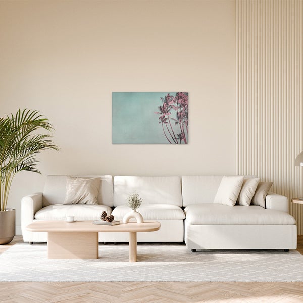 Wohnzimmer mit Sofa, Tisch und Wandbild mit Palmenmotiv