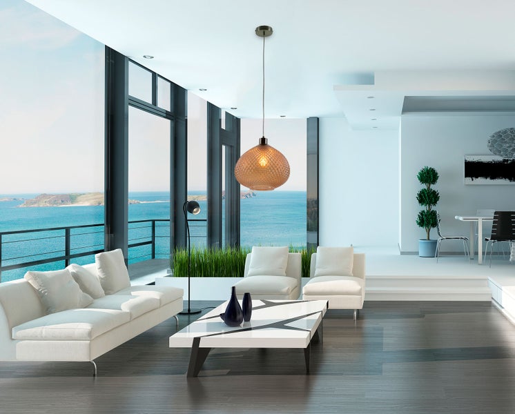 Wohnzimmer mit Pendelleuchte, Sofas, Couchtisch und großem Fenster mit Meerblick