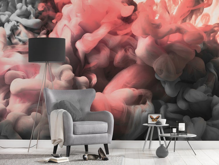 Fototapete mit abstrakten, wirbelnden Rauchwolken in Rosa und Grau in einem modern eingerichteten Wohnzimmer mit Sessel und Stehlampe.