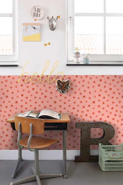 Kinderzimmer mit Schreibtisch, Stuhl, Dekor und Sternentapete.