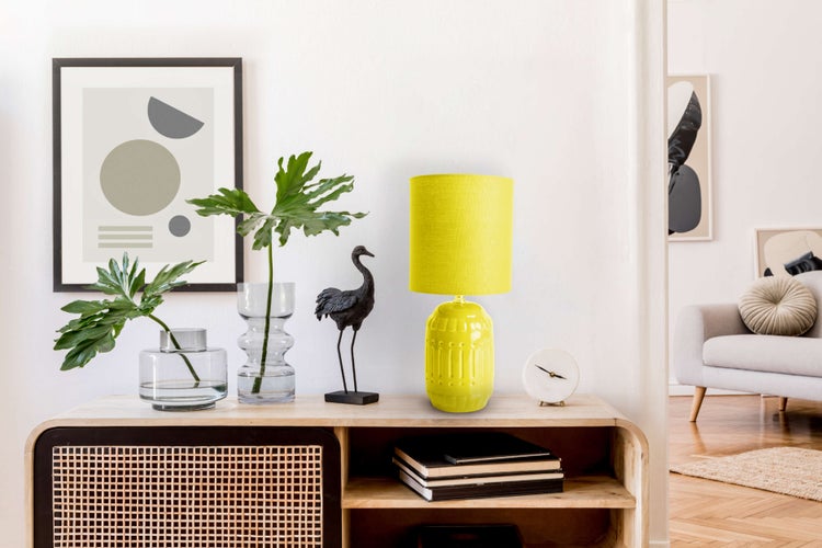 Dekorative Szene mit einem Holzschrank, einer Tischlampe, Vasen, einem Bild und einer Vogelfigur