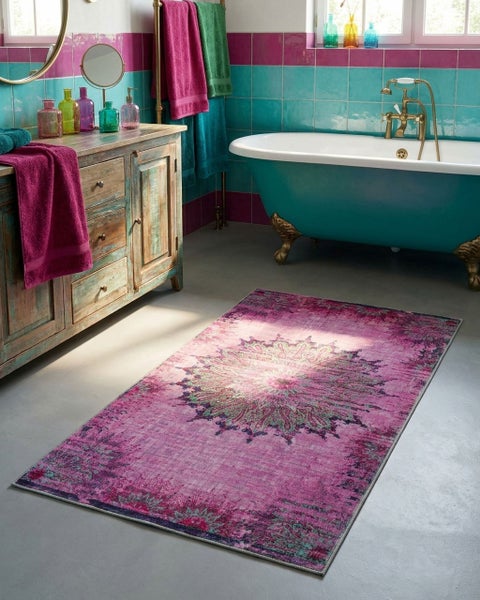 Helles Badezimmer mit freistehender Badewanne, rustikalem Waschtisch aus Holz und einem gemusterten Teppich.