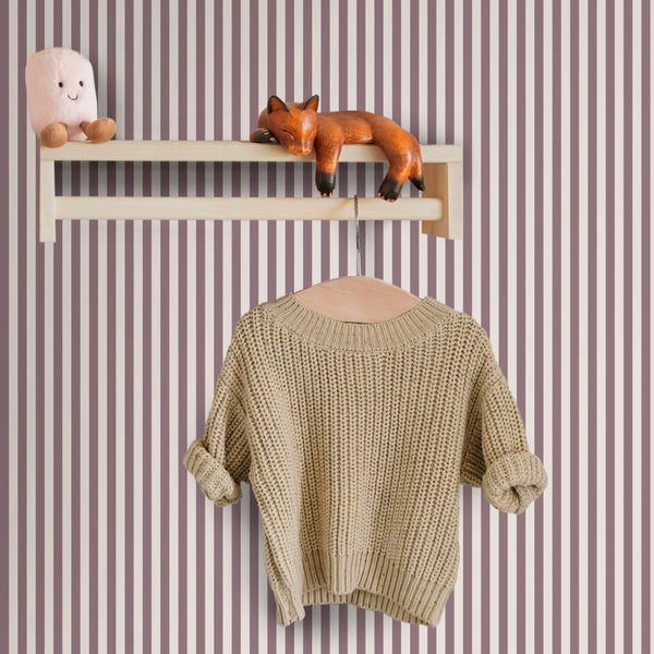 Gestreifte Vliestapete in einem Kinderzimmer mit Holzregal, Fuchsfigur, Stofftier und einem auf einem Kleiderbügel hängenden Strickpullover.