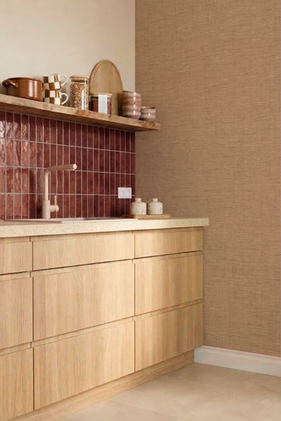 Moderne Küche mit hellen Holzunterschränken, glänzender Fliesenrückwand, Wand mit strukturierter Tapete in Leinenoptik und rustikalem Wandboard.