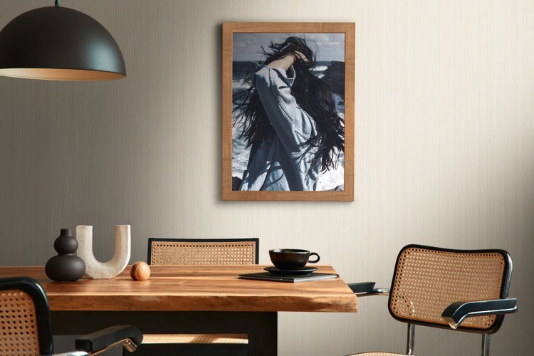 Szene mit Esstisch, Stühlen, Dekorationen und einem gerahmten Bild an der Wand