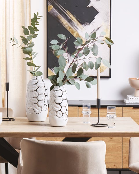 Dekoratives Esszimmer mit Vasen, Kerzenständern und abstraktem Gemälde