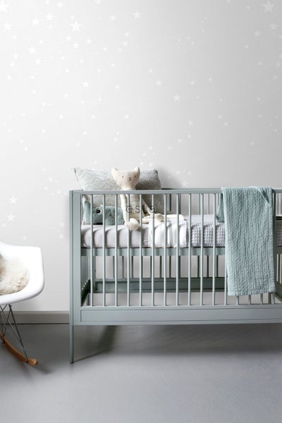 Babyzimmer mit Gitterbett, Kissen und Kuscheltieren